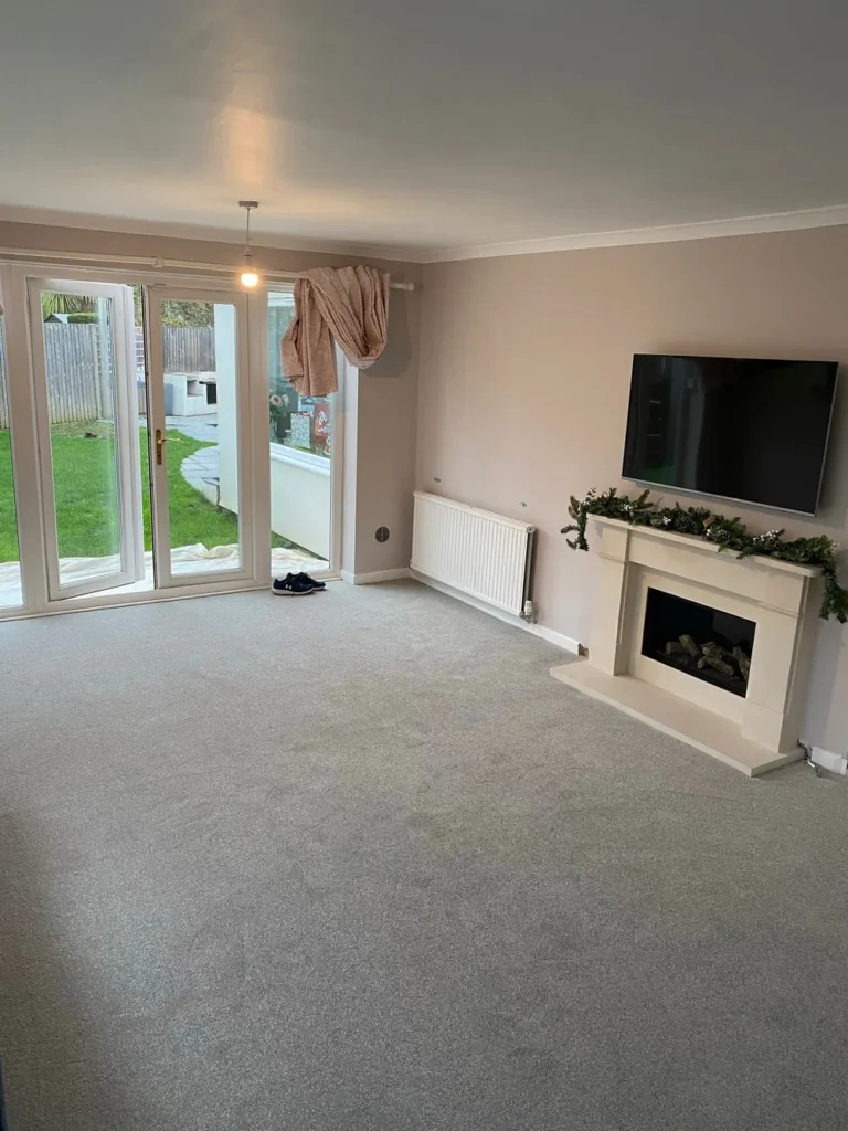 Living room with grey carpet, fireplace and French doors
