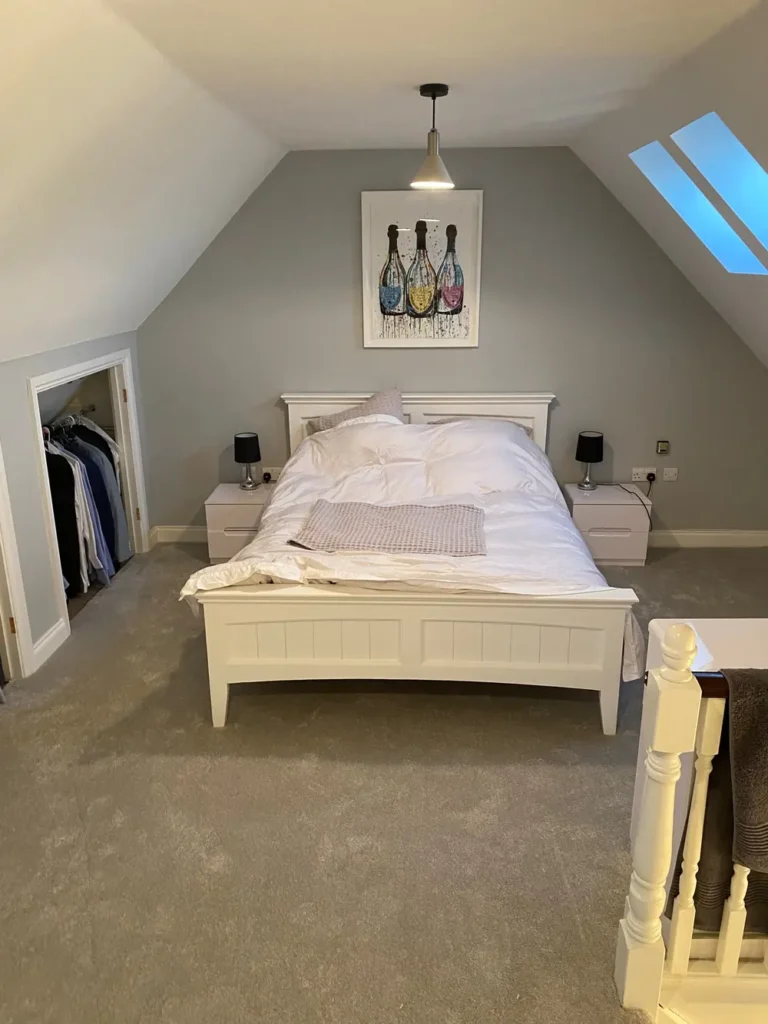 Loft bedroom with grey carpet and skylight